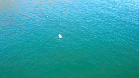 peaceful lone marker on vast water, serene aerial perspective of solitary device on open sea. Mediaの写真素材