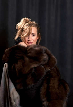Portrait of the beautiful woman in winter clothes removed in studioの写真素材