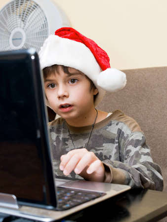 The boy writes the letter of Santa on email.の写真素材