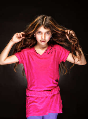The beautiful, young girl with a flowing hair, in a red dressの写真素材