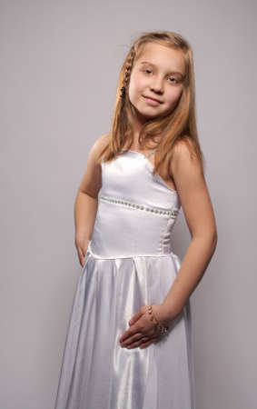 Smiling girl blonde in a white dressの写真素材