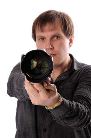 A young man with a camera in his hand, directed forward の写真素材