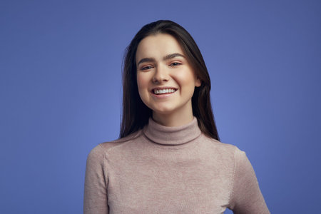 Young cute attractive girl looking at camera with joyful and charming smile