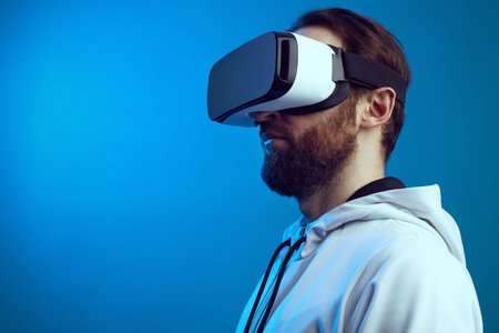 Side view of serious bearded guy in VR headset experiencing another world in studio, isolated over...