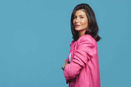 Side view photo of serious business woman dressed in stylish pink suit posing with crossed hands,...