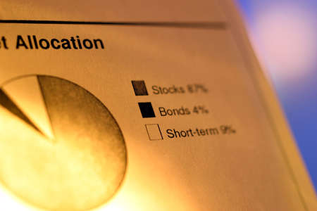 A closeup of a financial chart with pie graph. Graph legend reads: Stocks, Bonds, Short-term. Shallow depth of field with focus on graph legend.の写真素材