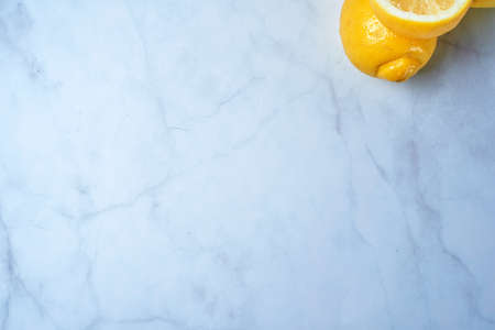 Top view of fresh lemons on kitchen marble. Grapefruit, open lemon and whole lemon, antioxidant vitamin on white background.の写真素材