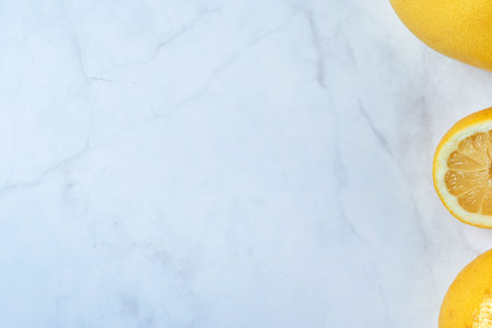 Top view of fresh lemons on kitchen marble. Grapefruit, open lemon and whole lemon, antioxidant...