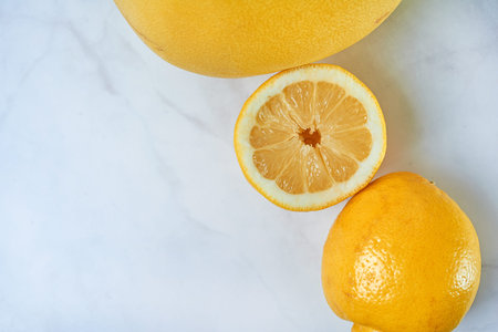 Top view of fresh lemons on kitchen marble. Grapefruit, open lemon and whole lemon, antioxidant...