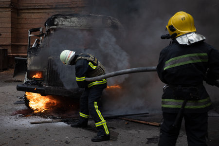 Firefighters extinguish a fire in an old car on the street