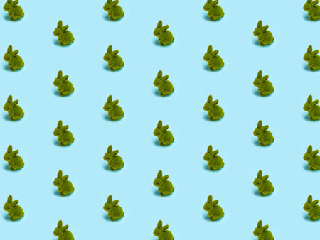 Trendy Easter pattern, little cute green grass rabbit, Easter bunny on bright light blue isolated...
