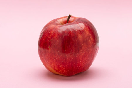 Red apple, on a pink background, Jonagold