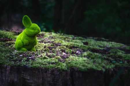 Easter bunny is sitting on a moss-covered tree trunk, concept, looking for eggs