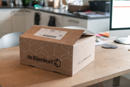 Amsterdam, the Netherlands, 10/26/2019. De Bijenkorf online package delivery, unboxing package, online shopping, fashion shoes, white sneakers, box on the tableのeditorial素材