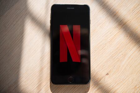 Amsterdam, The Netherlands, 02/06/2020, iphone 8 plus is on the table, Netflix start screen on mobile phone. Netflix online video, content streaming subscription service.のeditorial素材
