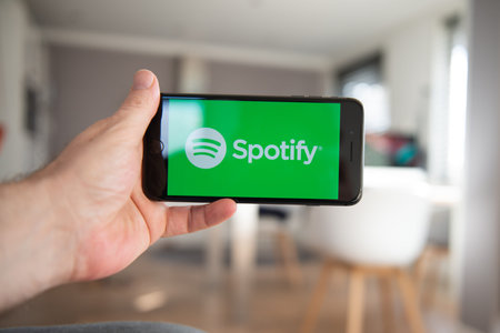 Amsterdam, The Netherlands, 02/06/2020, Man holding his phone, Spotify start screen on smartphone,...