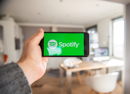 Amsterdam, The Netherlands, 02/06/2020, Man holding his phone, Spotify start screen on smartphone,...