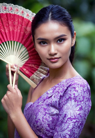 Beautiful Asian woman with a fan in the garden, Thailand.の素材