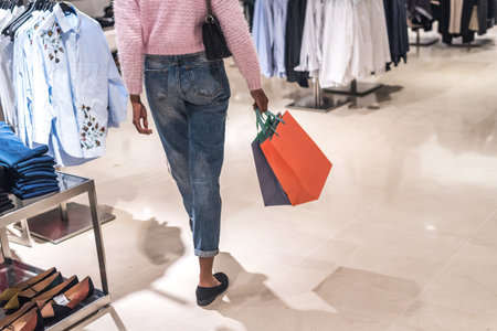 black Woman shopping with bags in a shopping center.