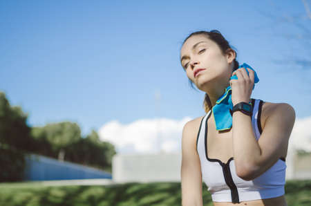 tired woman resting, relaxing and drinking water with towel after workout and do yogaの写真素材