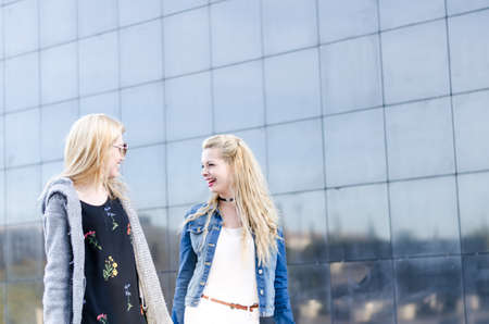 2 two women friends shopping with bags at the mall outdoorの写真素材