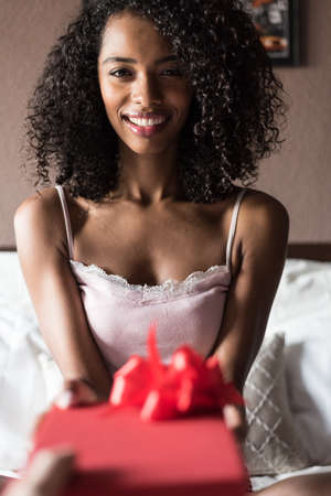 woman happy on bed with a gift on valentines or birthdayの写真素材