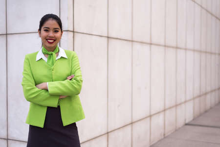 young pretty scort woman or crew smiling crossed arms greenの写真素材