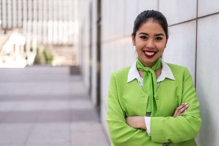 young pretty scort woman or crew smiling crossed arms greenの写真素材