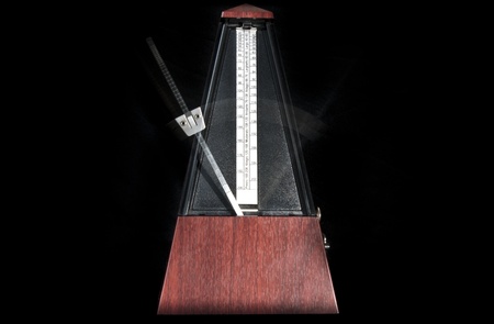 Wooden metronome working with black backgroundの写真素材