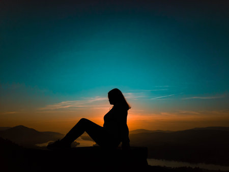 A woman sitting in profile at sunsetの写真素材