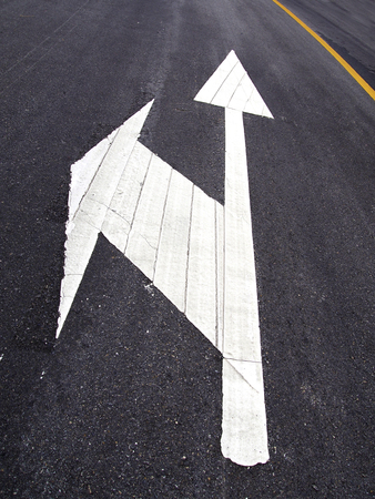 White arrow sign on the roadの写真素材