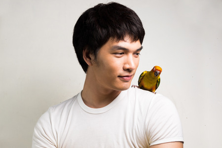 Asian men with parrot - Sun Conureの写真素材