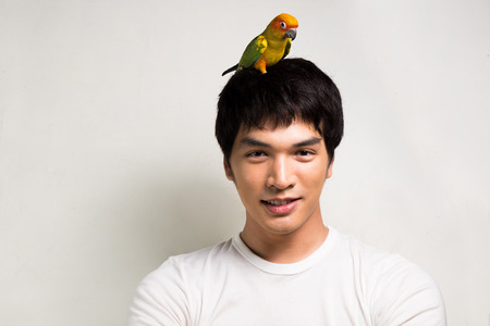 Asian men with parrot - Sun Conureの写真素材