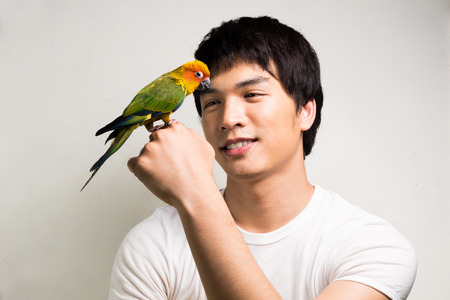 Asian men with parrot - Sun Conureの写真素材