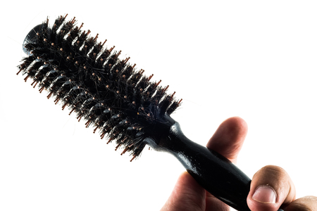 Round brush with hair fall in white backgroundの写真素材