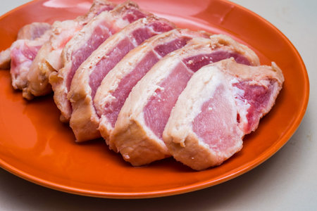 Raw sliced pork in the orange dish - Ingredientの写真素材
