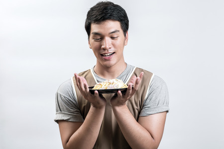 Asian man in apron with spaghetti carbonaraの写真素材