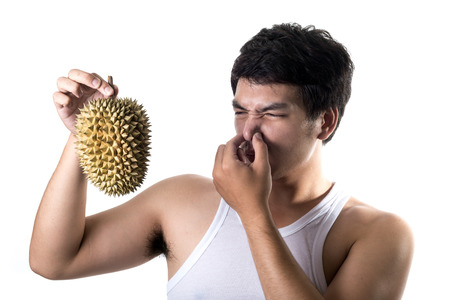 Asian man with bad smell of durian in white backgroundの写真素材