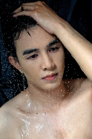 Asian man take a shower in the darkの写真素材