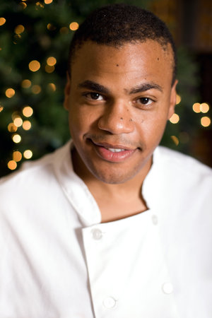Handsome young chef posing in the lobby of his restaurant