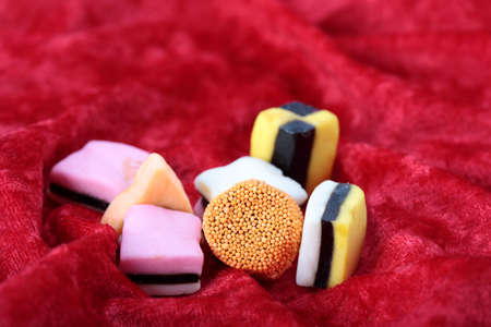Assorted colors of candy are placed on red velvet for that special person.の写真素材
