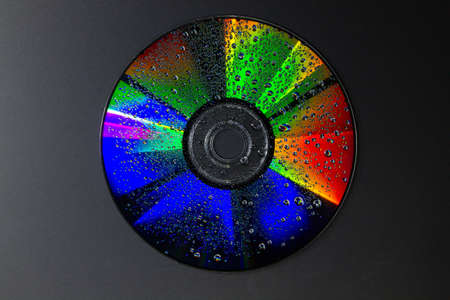 art photography with colours and water droplets on a dvd diskの写真素材