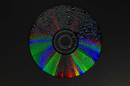 fantastic colours on a dvd disk with water dropletsの写真素材