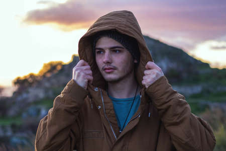 Guy in the mountain putting on the hood.の写真素材