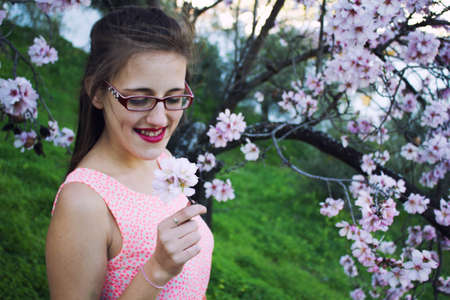 Girl in the countryside with a pink dress and surrounded by almond trees.の写真素材