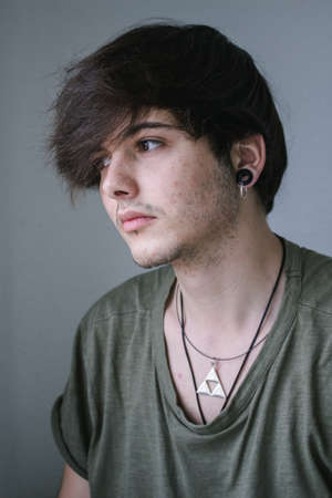Portrait of a young boy with a necklace and earring.の写真素材