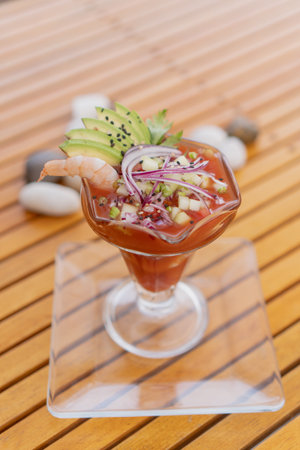 shrimp cocktail on wooden background with vegetables like avocado, purple onion, typical food from the seaの写真素材