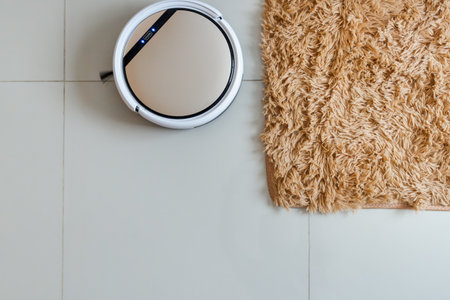 White robotic vacuum cleaner with towel on the floor, cleaning concept.の写真素材