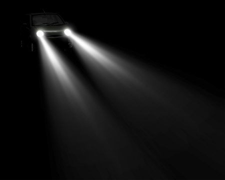 headlights beam of a car approaching in the darkの写真素材