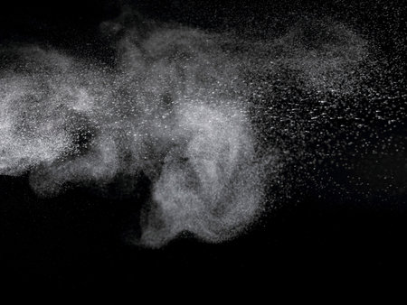 Abstract design of white powder cloud against dark backgroundの写真素材